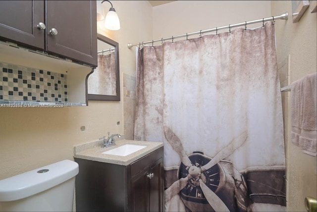 bathroom with decorative backsplash, vanity, toilet, and curtained shower