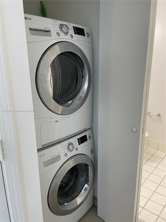 washroom featuring light tile patterned floors and stacked washer and clothes dryer