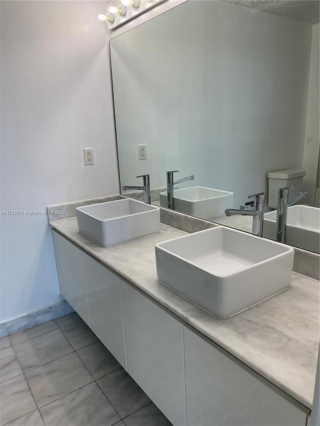 bathroom with tile patterned flooring, vanity, and toilet