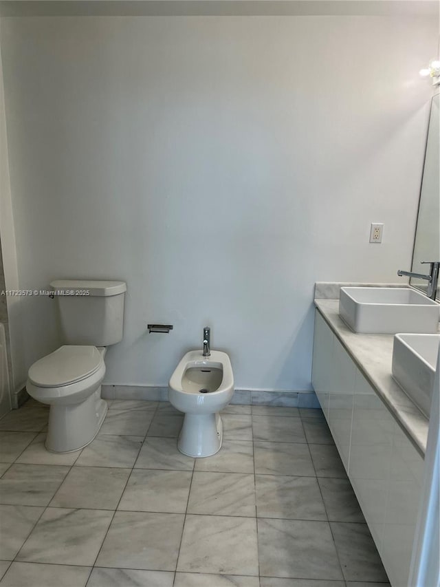 bathroom featuring toilet, a bidet, and sink