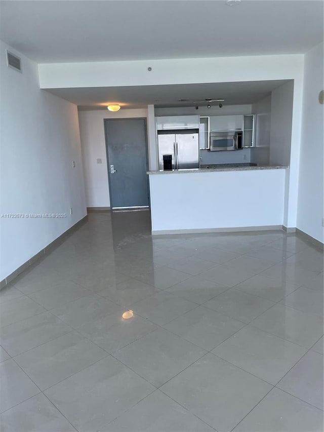 unfurnished living room with tile patterned floors