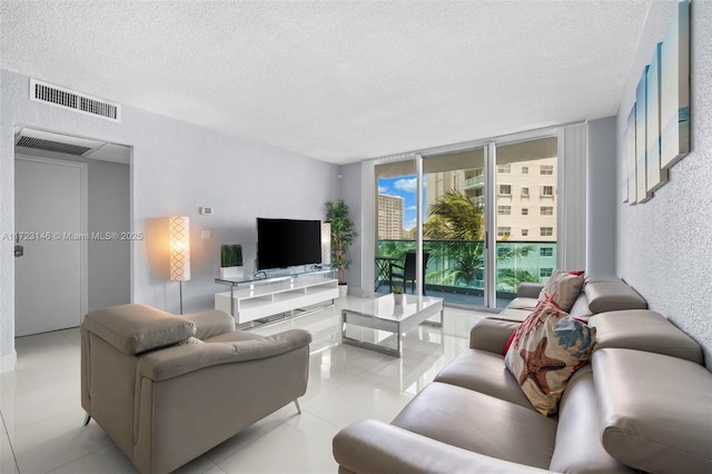 living room with floor to ceiling windows, light tile patterned floors, and a textured ceiling