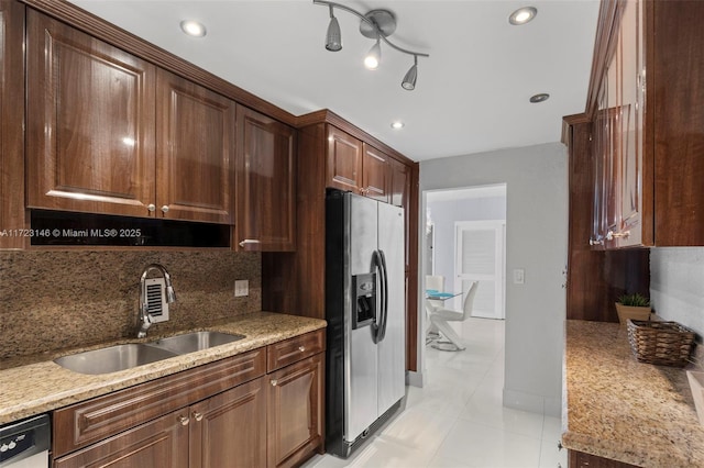 kitchen with sink, tasteful backsplash, light tile patterned flooring, light stone counters, and stainless steel appliances