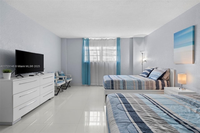 bedroom featuring light tile patterned floors and a textured ceiling