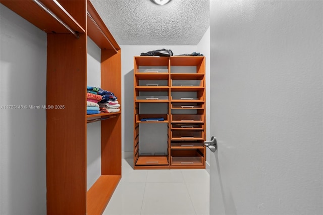 spacious closet with light tile patterned floors