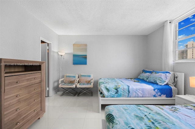 bedroom with light tile patterned floors and a textured ceiling