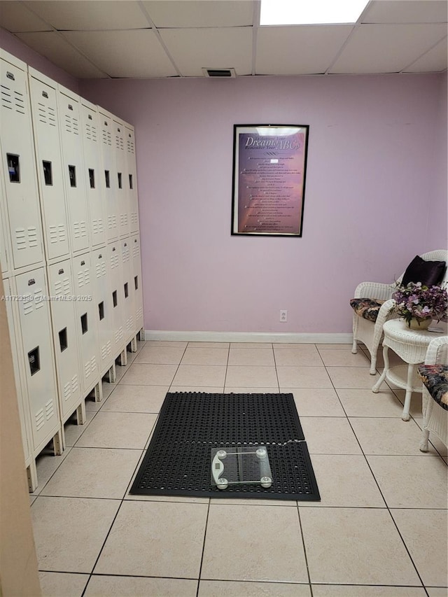 interior space featuring light tile patterned floors and a drop ceiling