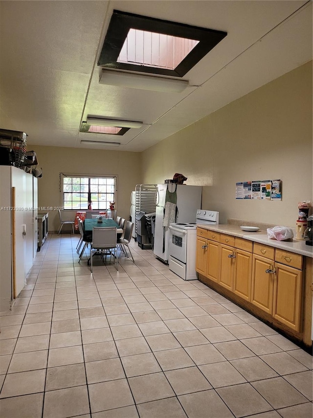 kitchen with white range with electric stovetop and light tile patterned flooring