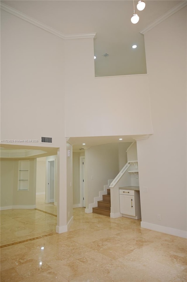 interior space with crown molding and a towering ceiling