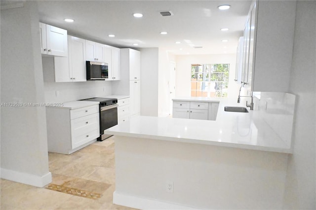 kitchen featuring kitchen peninsula, stainless steel appliances, sink, light tile patterned floors, and white cabinetry