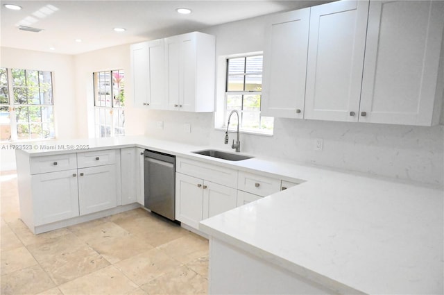 kitchen with decorative backsplash, kitchen peninsula, white cabinets, sink, and dishwasher