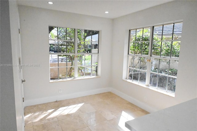 tiled spare room featuring a healthy amount of sunlight