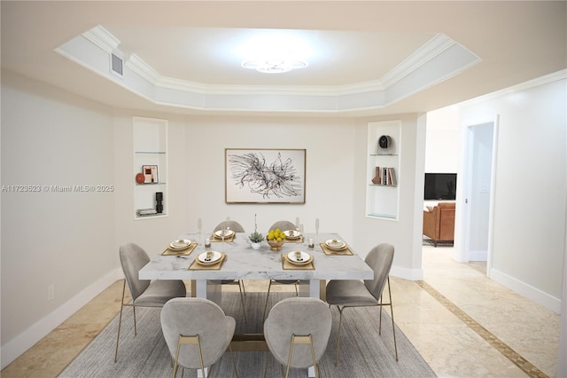 dining space with built in shelves, a tray ceiling, and ornamental molding