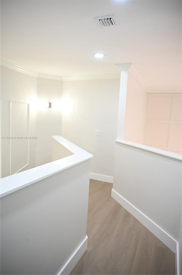 corridor featuring hardwood / wood-style floors and ornamental molding