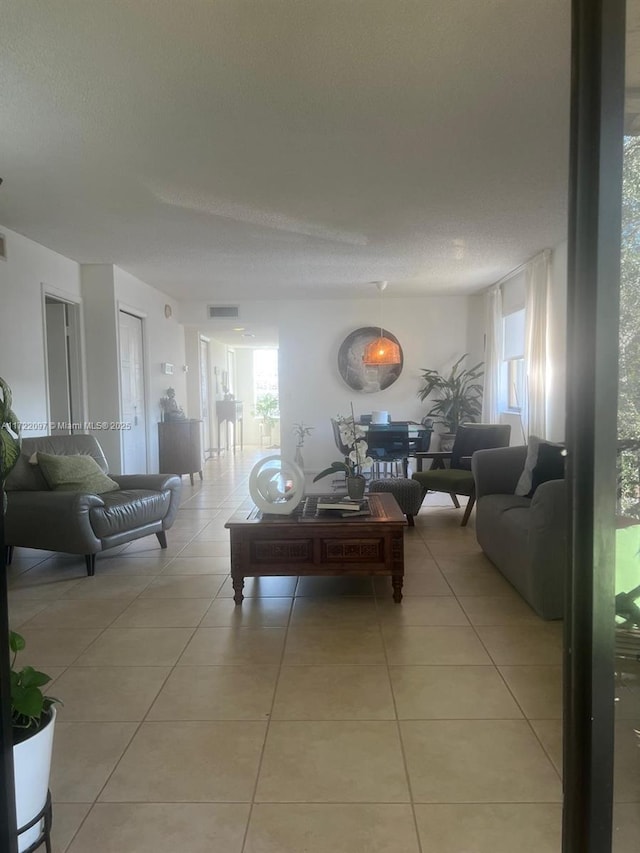 living room featuring a wealth of natural light, light tile patterned floors, and a textured ceiling