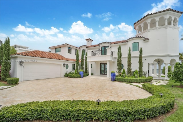 mediterranean / spanish home featuring french doors, a balcony, and a garage