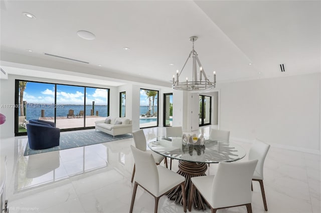 dining room with floor to ceiling windows, a water view, and an inviting chandelier