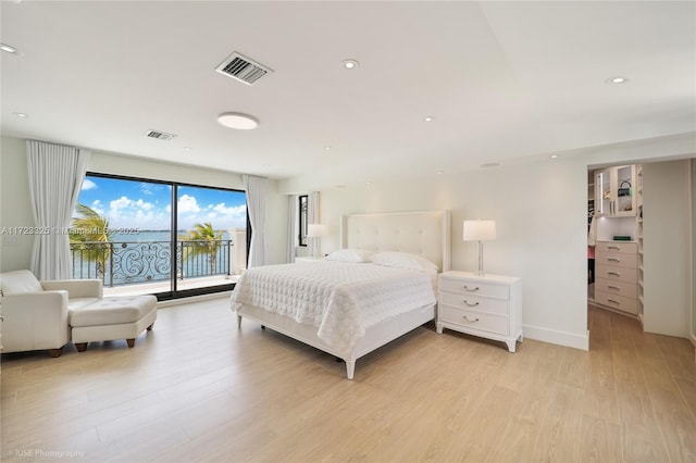 bedroom featuring light wood-type flooring and access to outside