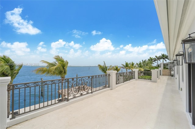 view of patio featuring a water view and a balcony