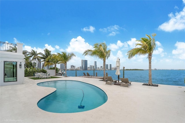 view of pool with a water view and a patio