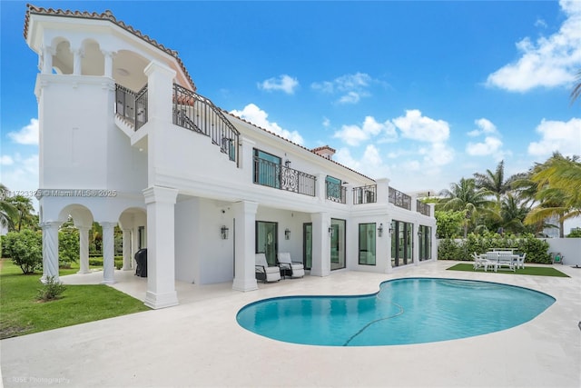 rear view of house with a balcony and a patio