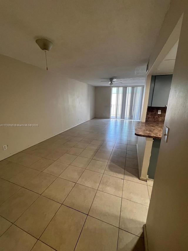 tiled spare room with ceiling fan