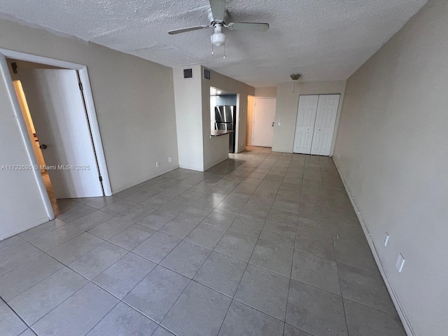 unfurnished room with light tile patterned floors, a textured ceiling, and ceiling fan