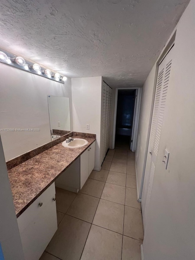 bathroom featuring tile patterned flooring, vanity, and a textured ceiling