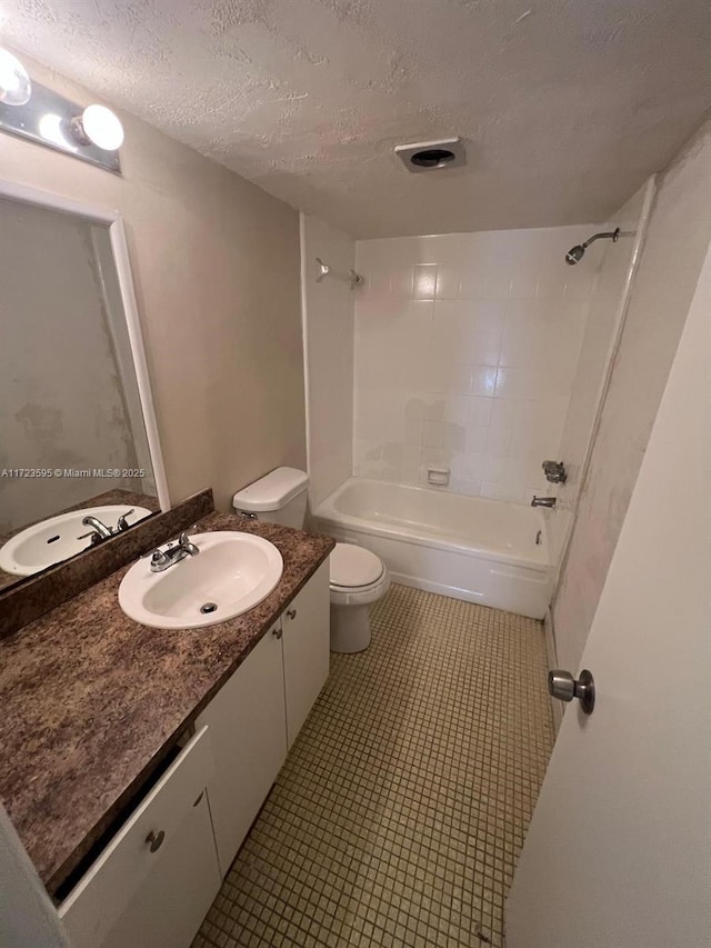 full bathroom featuring vanity, a textured ceiling, toilet, and tiled shower / bath