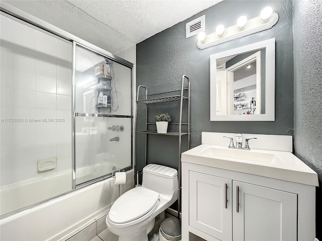 full bathroom featuring shower / bath combination with glass door, vanity, a textured ceiling, and toilet