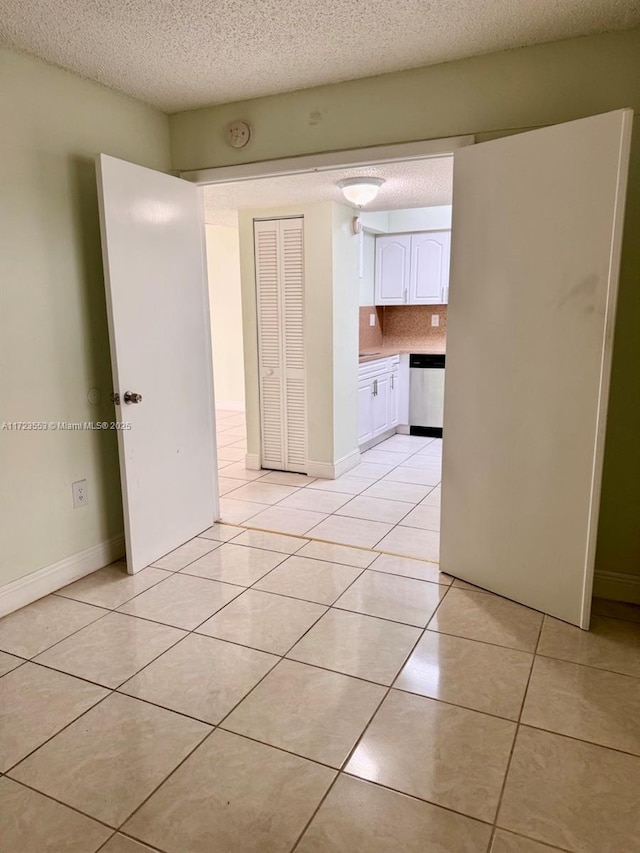 empty room with light tile patterned floors and a textured ceiling