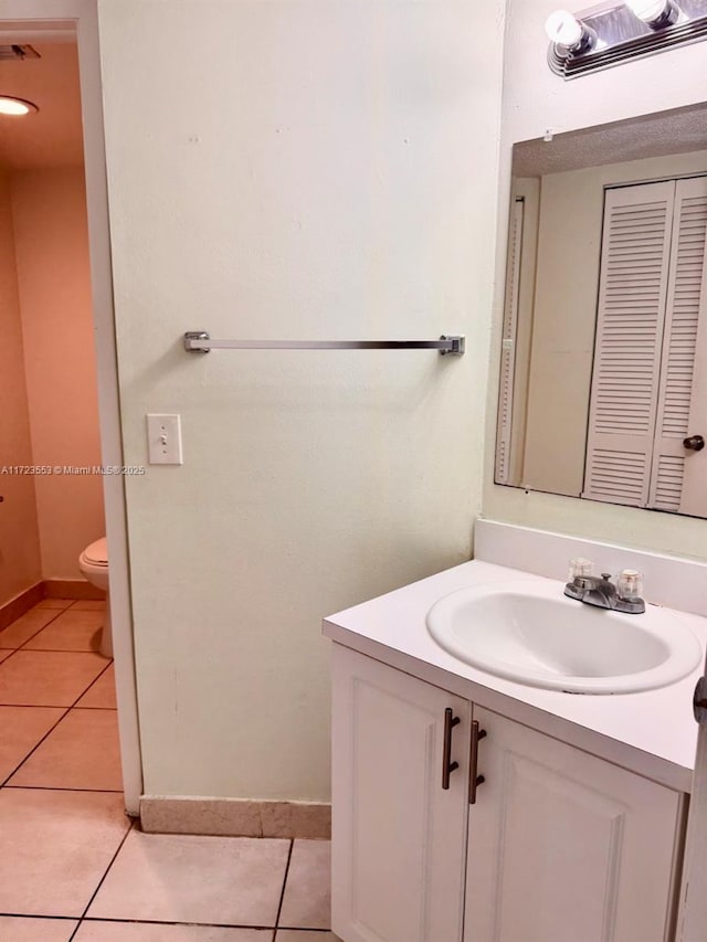 bathroom featuring tile patterned flooring, vanity, and toilet