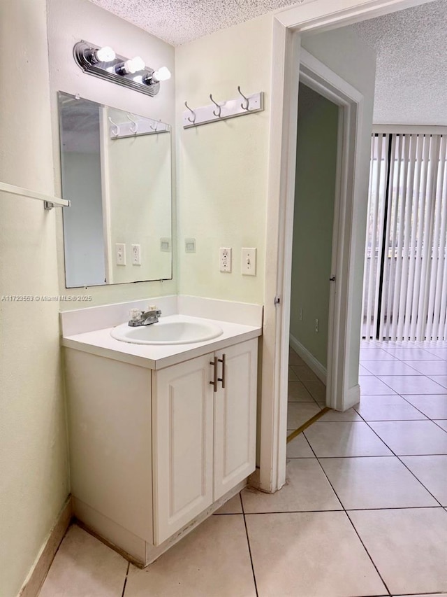 bathroom with tile patterned flooring, vanity, and a textured ceiling