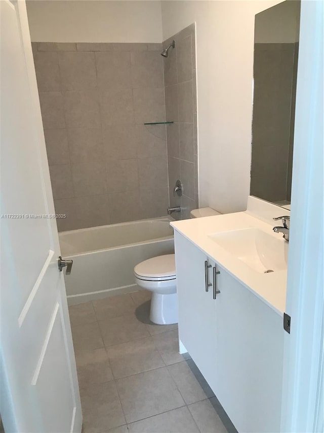 full bathroom featuring tile patterned floors, vanity, toilet, and tiled shower / bath combo