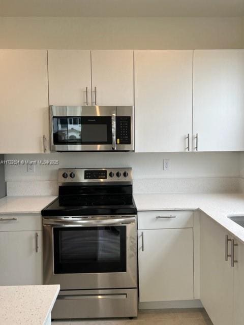 kitchen featuring white cabinetry and appliances with stainless steel finishes