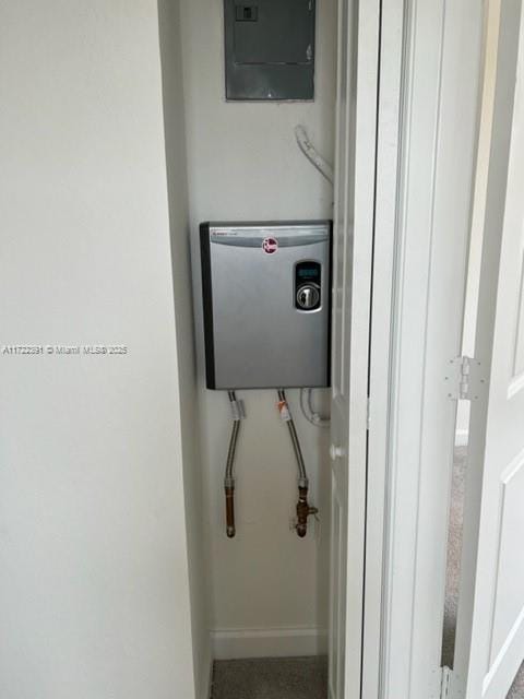 utility room featuring electric panel and water heater