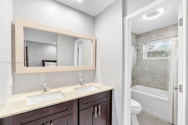 full bathroom featuring tiled shower / bath combo, toilet, and vanity