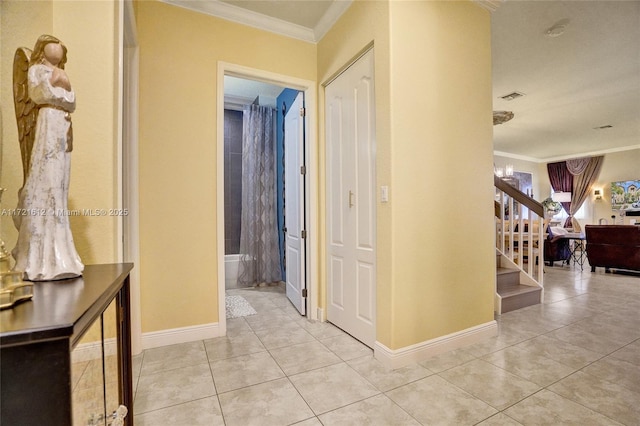 hallway with light tile patterned floors, crown molding, and a chandelier