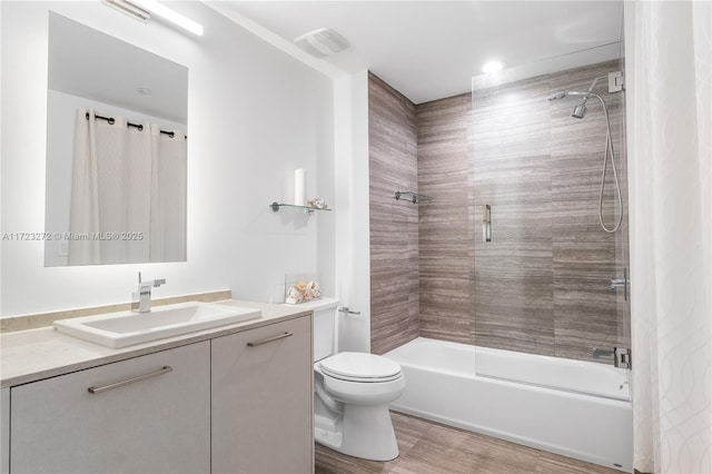 full bathroom featuring tiled shower / bath combo, toilet, and vanity