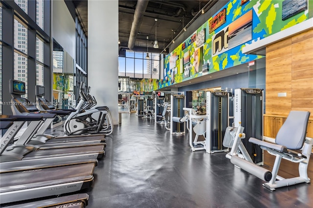 gym featuring a high ceiling and wood walls