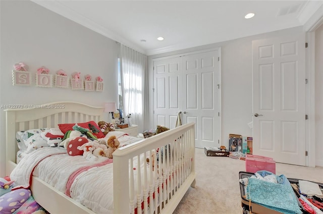 bedroom with carpet floors, crown molding, and a closet