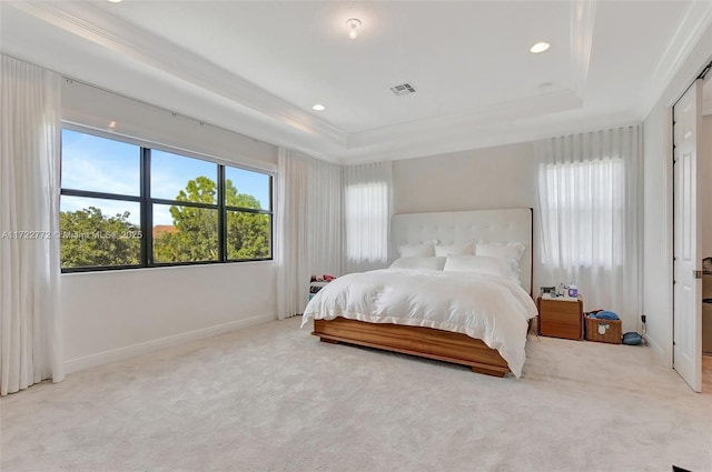 bedroom with a raised ceiling and light carpet