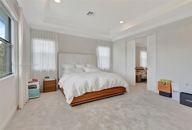 bedroom featuring light carpet, a raised ceiling, and ornamental molding