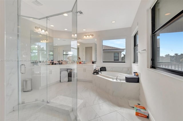 bathroom with vanity and shower with separate bathtub