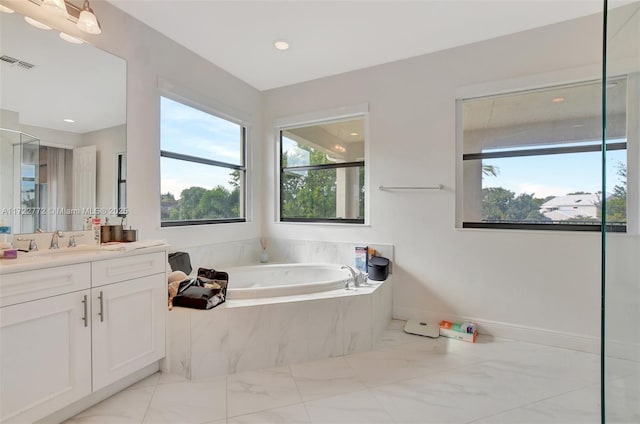 bathroom with vanity and tiled bath