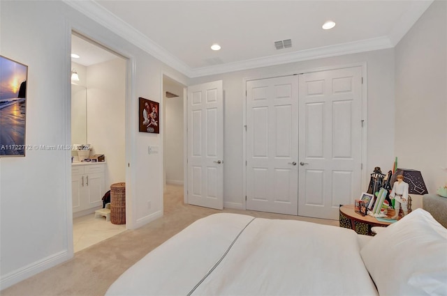 carpeted bedroom featuring ensuite bath, a closet, and ornamental molding