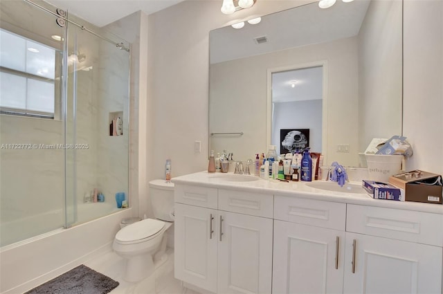 full bathroom with tile patterned flooring, toilet, vanity, and combined bath / shower with glass door