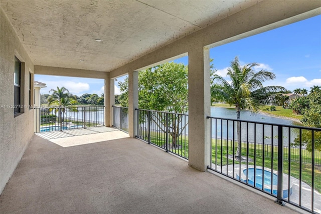 view of patio / terrace with a water view, a fenced in pool, and a balcony