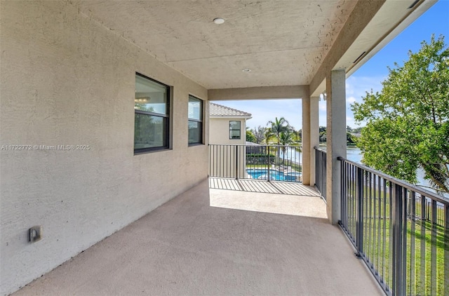 view of patio featuring a balcony and a water view