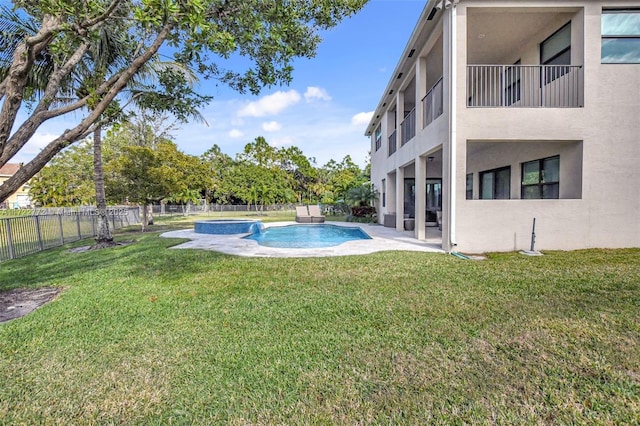 view of pool with a patio and a lawn